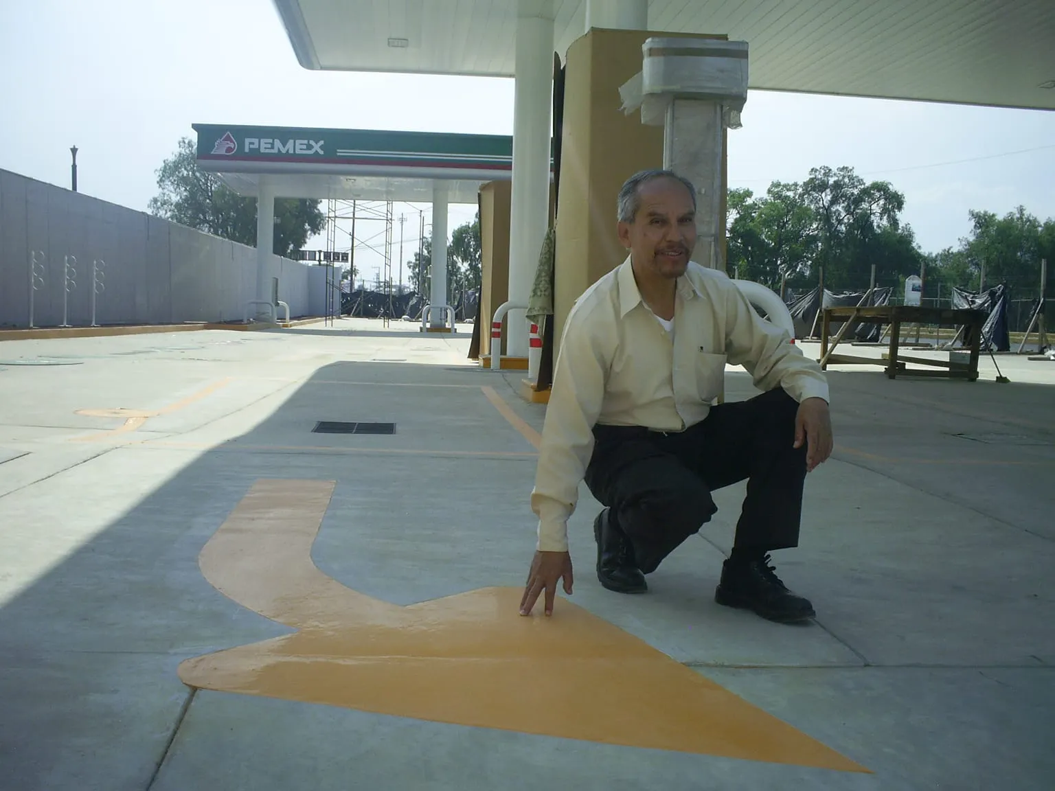 Un hombre observa la aplicación de pinturas de señalización vial que cumplen con las estrictas Normas PEMEX.